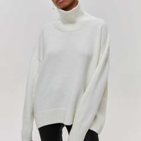 Lydia turtleneck sweater in white, worn with black trousers